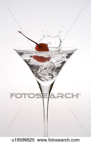 Stock Photography - Cherry splashing water from a martini glass. Fotosearch