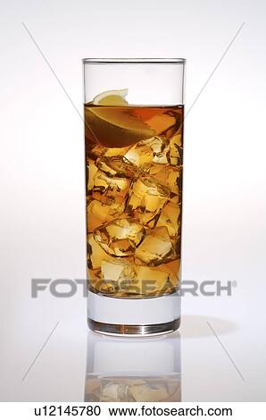 Stock Image - Glass of cold black tea, with ice cubes and a slice of lemon. Fotosearch