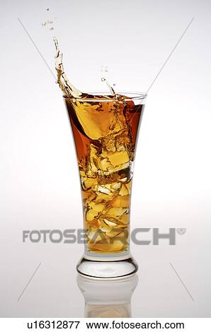 Stock Photo - Glass of iced black tea, tea splashing out of the glass. Fotosearch