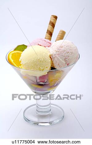 Picture - Strawberry and vanilla ice cream in a glass, with cookies and fruit garnish. Fotosearch