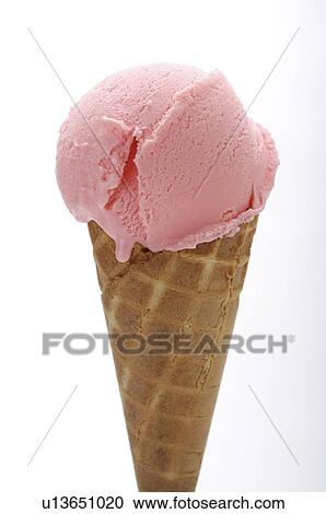Stock Image - Strawberry ice cream in a cone, close-up. Fotosearch