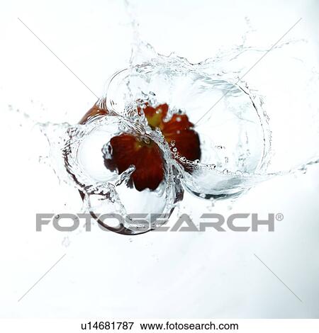 Stock Photo - An apple falling into water, creating water ripples. Fotosearch