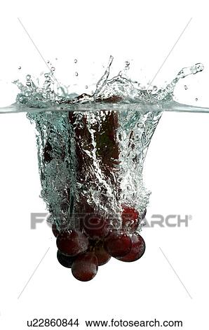 Picture - Bunch of red grapes falling into water. Fotosearch