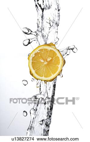 Picture - Cross-section of a lemon, in a falling stream of water. Fotosearch