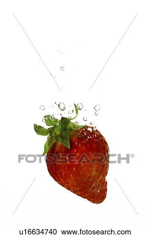 Stock Image - Red strawberry in water, with water bubbles. Fotosearch