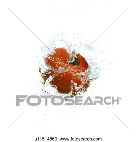 Stock Image - Red tomato falling into water, creating water ripples. Fotosearch