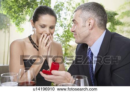 Stock Image - Man proposing woman with engagement ring. Fotosearch