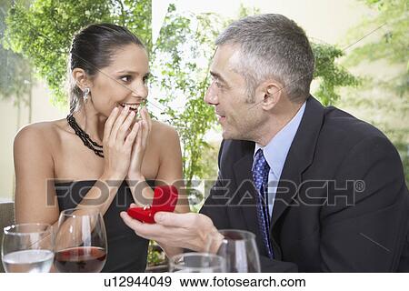Man proposing woman with engagement ring View Large Photo Image Stock Photo - Man proposing woman with engagement ring. Fotosearch