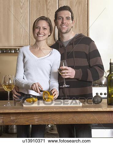 Stock Image - Mid-Adult Couple Cooking. Fotosearch