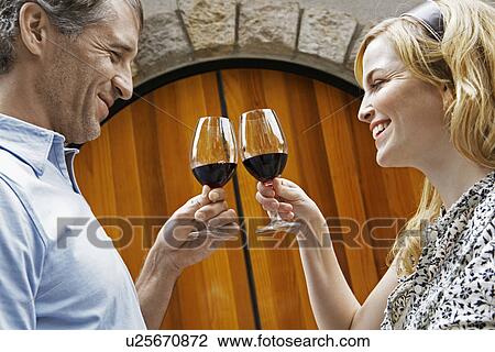 Mid Adult Couple Toasting with Red Wine View Large Photo Image Stock Image - Mid Adult Couple Toasting with Red Wine. Fotosearch