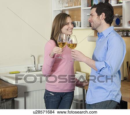 Mid-Adult Couple Toasting with White Wine View Large Photo Image Picture - Mid-Adult Couple Toasting with White Wine. Fotosearch