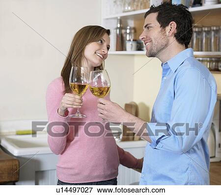 Stock Photo - Mid-Adult Couple Toasting with White Wine. Fotosearch