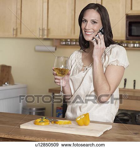 Mid-Adult Woman on Phone While Cooking View Large Photo Image Stock Photo - Mid-Adult Woman on Phone While Cooking. Fotosearch