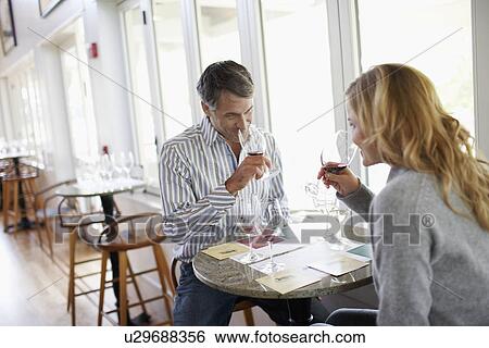 Stock Photograph - Woman and man smelling red wine. Fotosearch