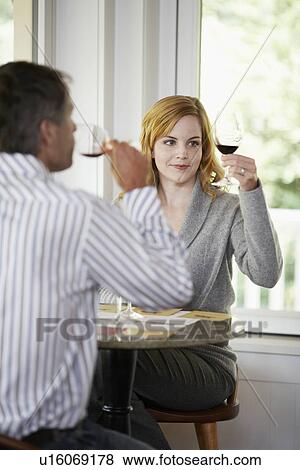 Woman and man tasting red wine (focus on background) View Large Photo Image Stock Photo - Woman and man tasting red wine (focus on background). Fotosearch
