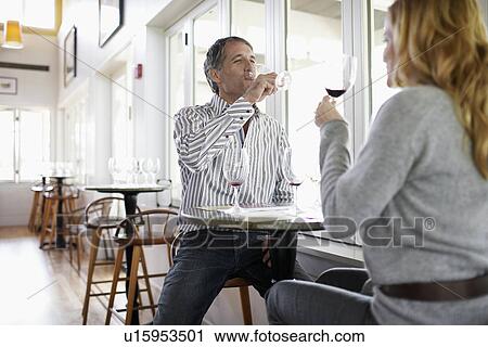 Stock Image - Woman and man tasting red wine. Fotosearch