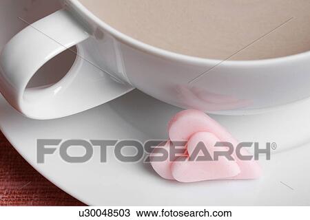 Stock Image - Heart shaped candies and latte (close-up). Fotosearch