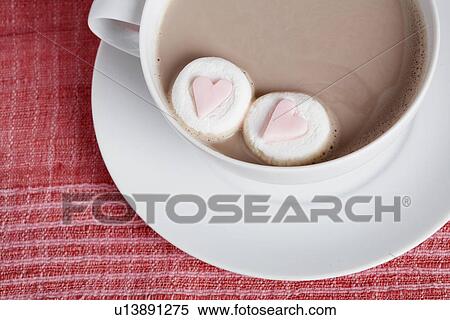 Stock Photography - Heart shaped candies in cappuccino (close-up, directly above). Fotosearch