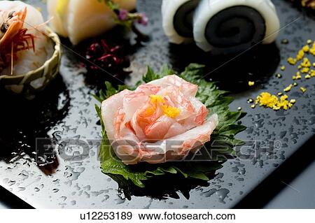 Stock Photo - Sliced raw fishes on a tray, high angle view, close up, Japan. Fotosearch