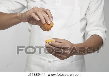 Chef cracking brown egg (mid section) View Large Photo Image Stock Image - Chef cracking brown egg (mid section). Fotosearch
