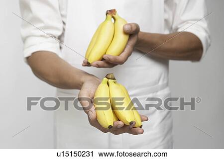 Chef holding bunches of bananas (mid section) View Large Photo Image Stock Image - Chef holding bunches of bananas (mid section). Fotosearch