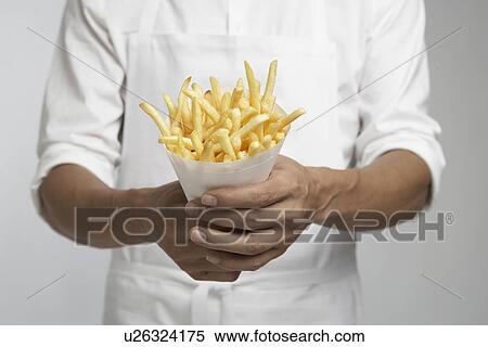 Stock Photography - Chef holding french fries (mid section). Fotosearch