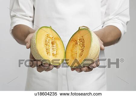Chef holding halved cantaloupe melon (mid section) View Large Photo Image Stock Photography - Chef holding halved cantaloupe melon (mid section). Fotosearch