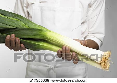 Stock Photo - Chef holding leeks (mid section). Fotosearch
