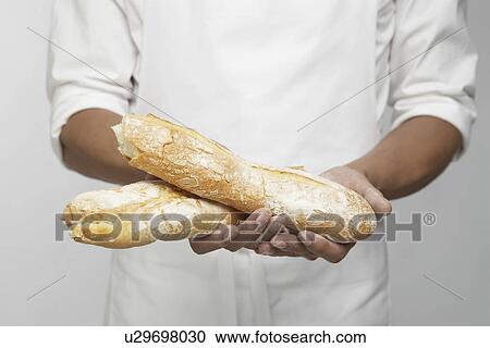 Chef holding two pieces of baguette (mid section) View Large Photo Image Stock Image - Chef holding two pieces of baguette (mid section). Fotosearch