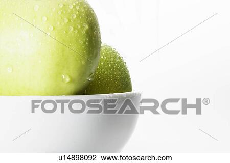 Stock Image - Water droplets on green apples (close-up). Fotosearch