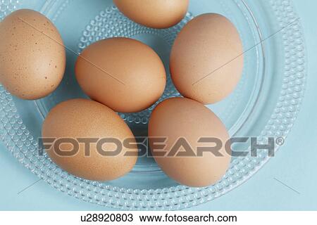 Stock Image - Brown eggs on plate (close-up, directly above). Fotosearch