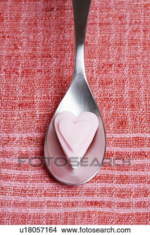 Pink heart shaped candies on table spoon View Large Photo Image Picture - Pink heart shaped candies on table spoon. Fotosearch