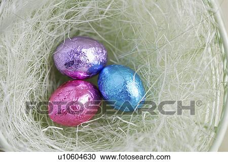 Stock Image - Three Easter egg candies in bowl (close-up, directly above). Fotosearch