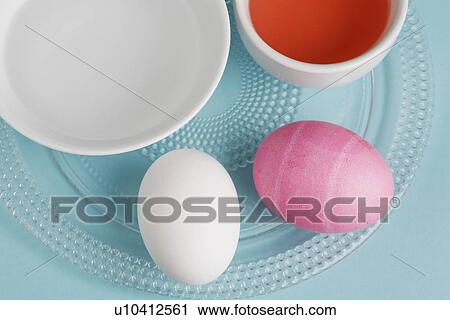 Stock Image - Two eggs by Easter egg dye (close-up, directly above). Fotosearch