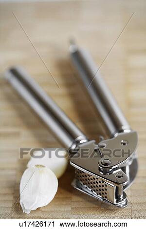 Stock Image - Garlic press and garlic gloves. Fotosearch