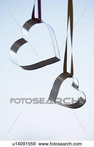 Two heart shaped cookie cutters hanging (close-up) View Large Photo Image Stock Photo - Two heart shaped cookie cutters hanging (close-up). Fotosearch
