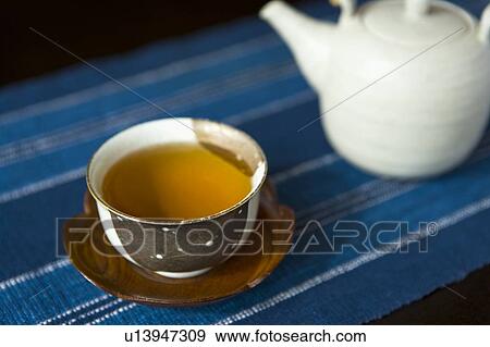 High Angle View of a Tea Cup Filled with Tea and a Tea Pot in the Background, Differential Focus, Close Up View Large Photo Image Stock Photo - High Angle View of a Tea Cup Filled with Tea and a Tea Pot in the Background, Differential Focus, Close Up. Fotosearch