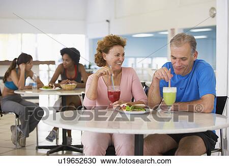 Stock Image - Mature couple eating in health club café. Fotosearch