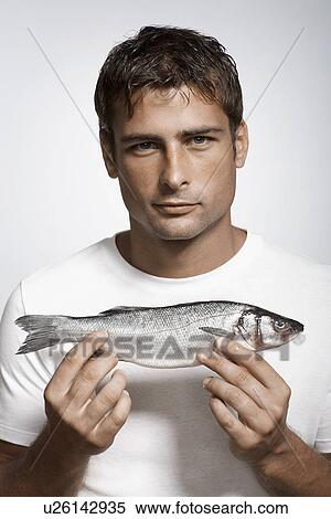 Mid adult man holding striped sea bass View Large Photo Image Stock Photography - Mid adult man holding striped sea bass. Fotosearch