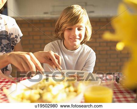 Mother helping son with food View Large Photo Image Stock Image - Mother helping son with food. Fotosearch