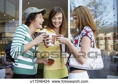 Three teenage girls drinking take-out coffees and eating cakes View Large Photo Image Picture - Three teenage girls drinking take-out coffees and eating cakes. Fotosearch