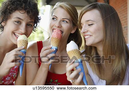 Stock Image - Three teenage girls eating ice creams. Fotosearch