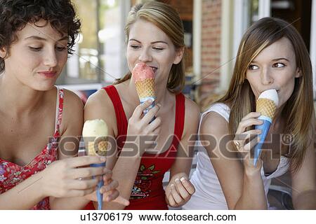 Stock Photo - Three teenage girls eating ice creams. Fotosearch
