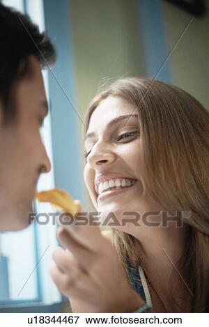 Stock Photo - Woman feeding man with cookie. Fotosearch