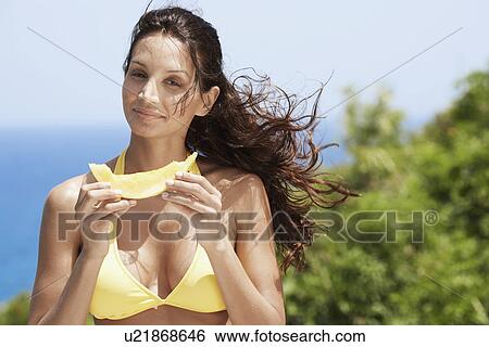 Stock Photograph - Young woman eating melon. Fotosearch