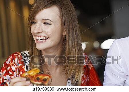 Young woman eating pizza in cafe View Large Photo Image Stock Photo - Young woman eating pizza in cafe. Fotosearch