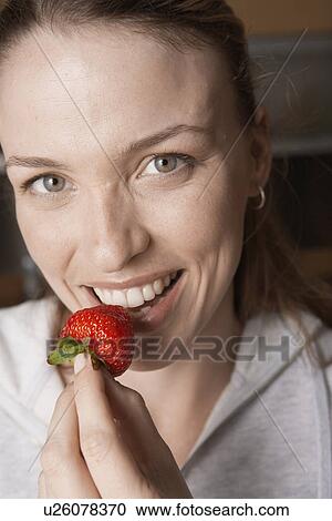 Young woman eating strawberry (portrait) View Large Photo Image Stock Image - Young woman eating strawberry (portrait). Fotosearch