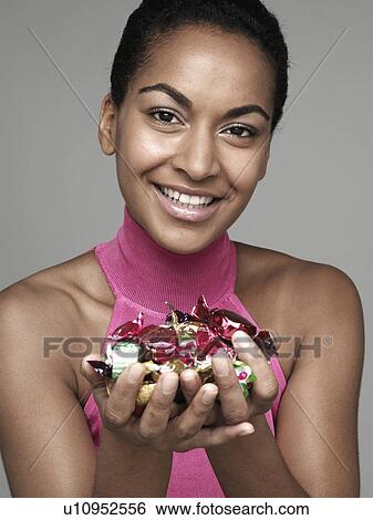 Stock Photograph - Young woman holding candies. Fotosearch