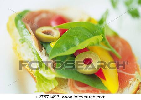 Stock Image - Mixed salad leaves with ham on baguette, close up, Differential Focus. Fotosearch