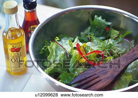 Mixed salad leaves with wooden fork in bowl, two bottles visible in background, Differential Focus View Large Photo Image Stock Photo - Mixed salad leaves with wooden fork in bowl, two bottles visible in background, Differential Focus. Fotosearch